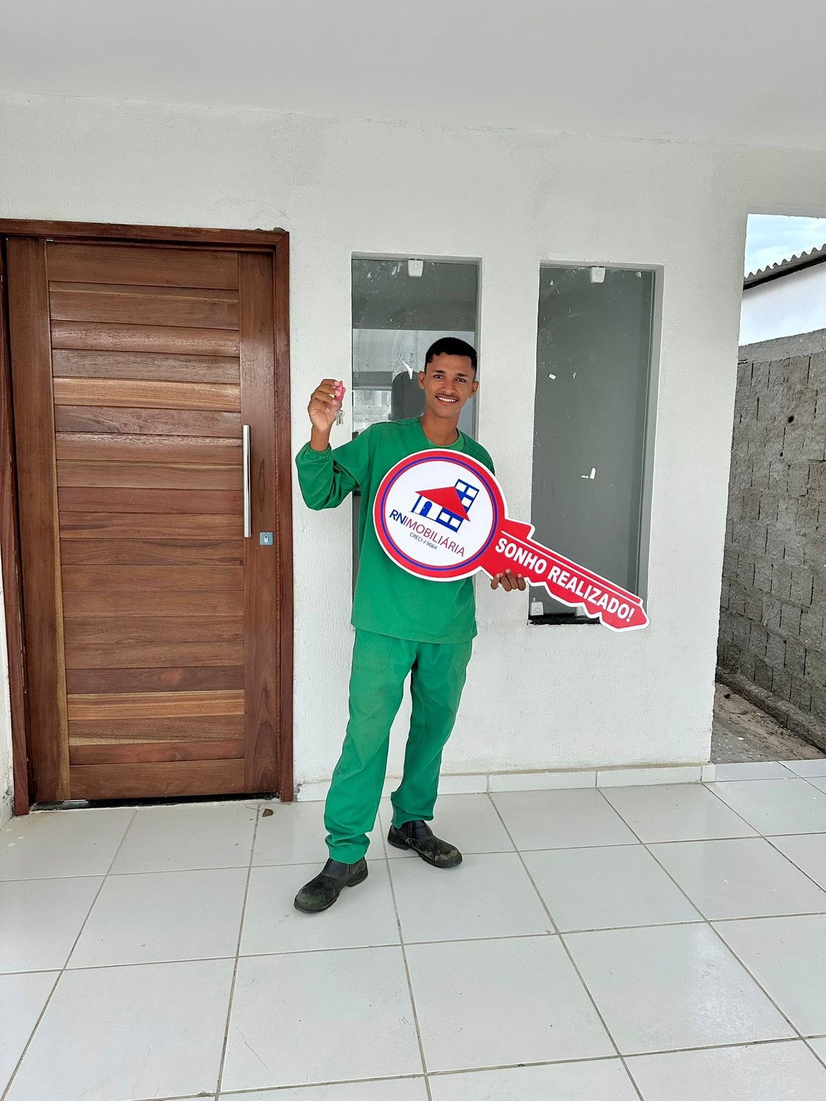 Cliente RN Imobiliária com a chave Sonho Realizado